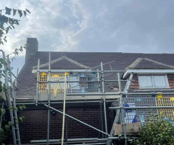 This is a photo of a roof with two dormers that is having some damaged tiles replaced. Works carried out by WCT Roofing Long Buckby