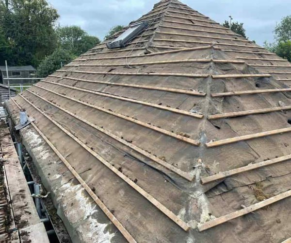 This is a photo of a hip roof that has been stripped back to the battens, and is awaiting a new roof covering to be installed. Works carried out by WCT Roofing Long Buckby